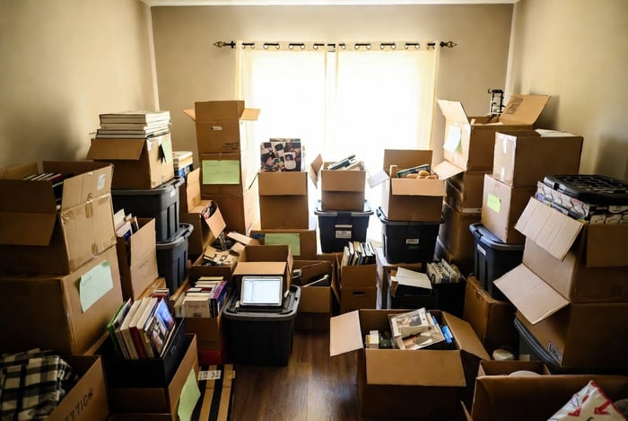 A cluttered living room filled with overflowing boxes